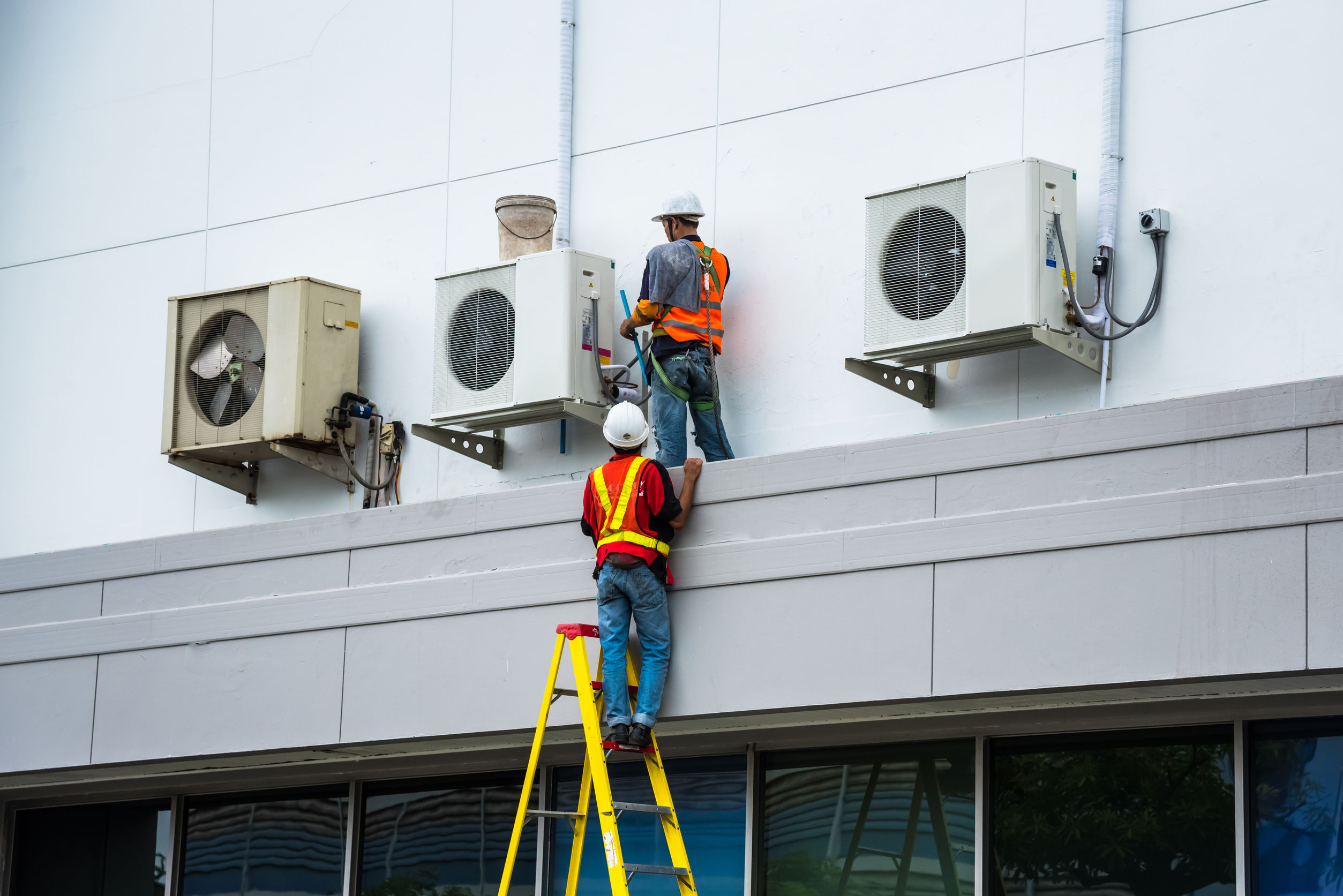 Technicians serviciing air conditioners